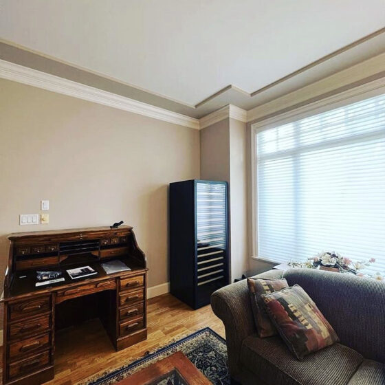 Cave de vieillissement EuroCave installée en pose libre dans un salon-bureau traditionnel avec mobilier en bois