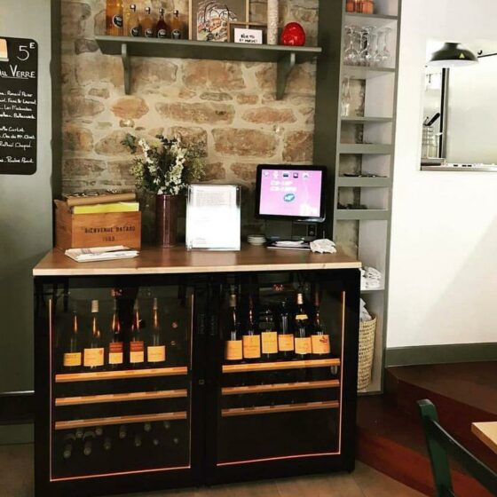 Caves à vin EuroCave installées sous un comptoir de restaurant avec bouteilles en présentation