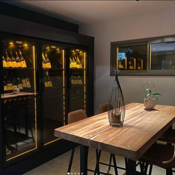 Caves à vin EuroCave Revelation intégrées dans une salle à manger contemporaine avec éclairage ambré